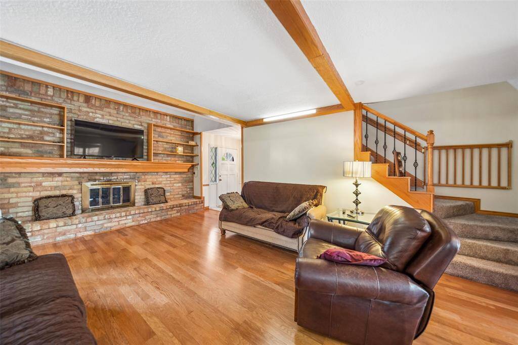 Cozy living room featuring a brick fireplace and built-in shelving.