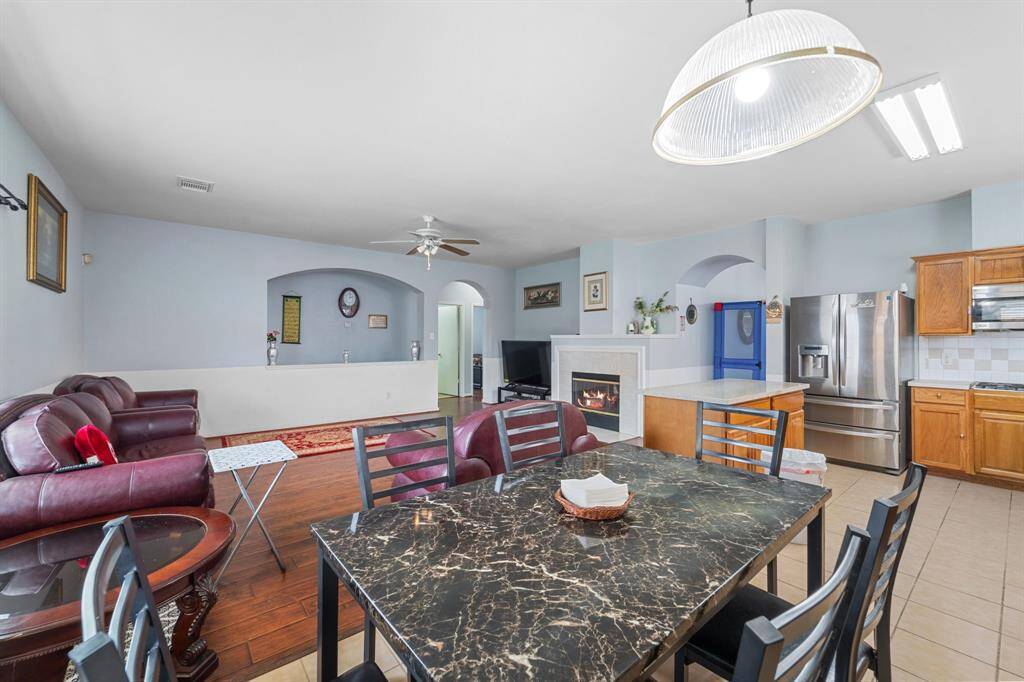 This spacious open-concept living area features a cozy fireplace, modern ceiling fan, and natural light.  The layout is perfect for entertaining and family gatherings.