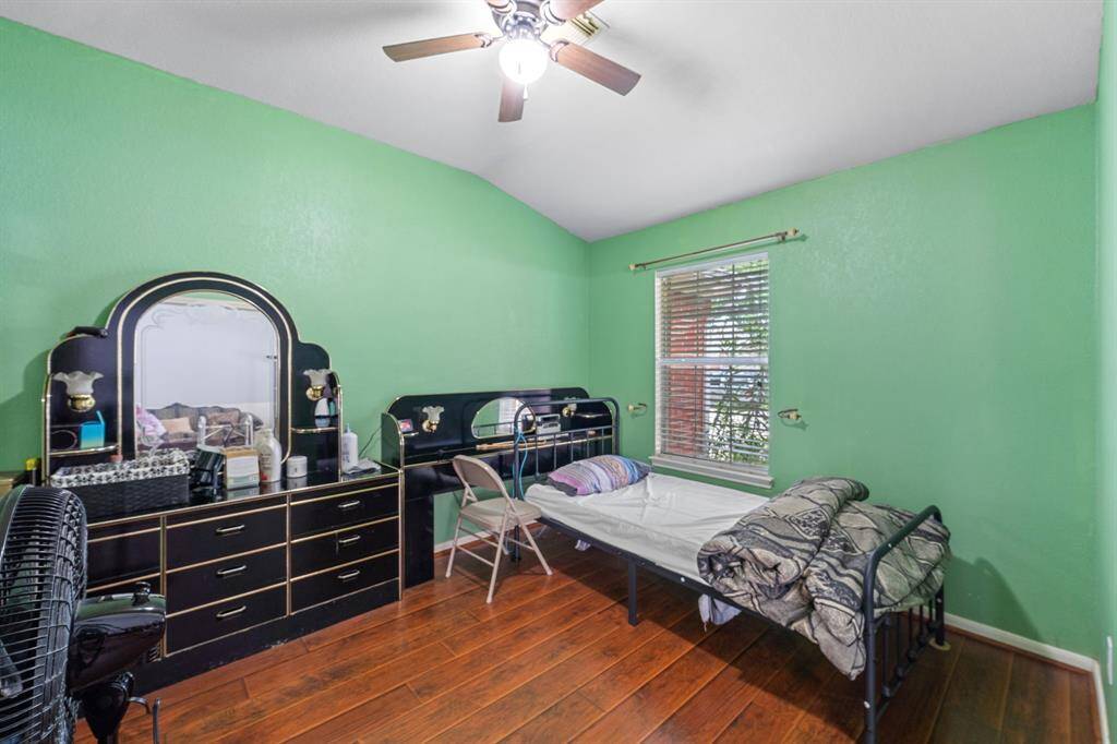 Cozy bedroom with hardwood flooring, and a ceiling fan.
