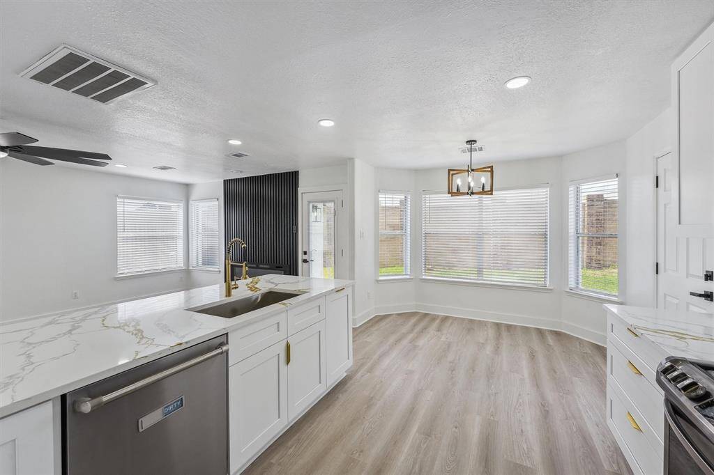 The cozy breakfast nook is surrounded by large windows, flooding the space with natural light and offering serene views.