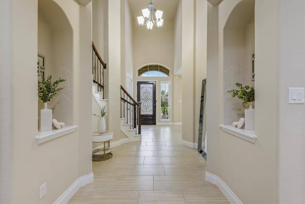 A clear view down the hall leads to the front door, framed by natural light and clean, welcoming lines.