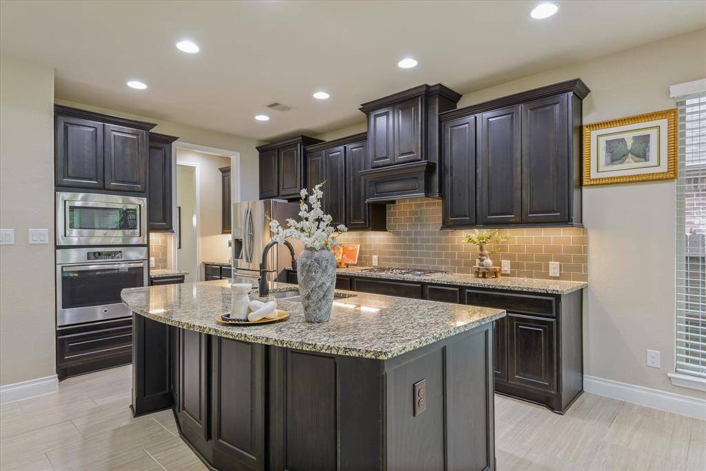 Sleek kitchen with glowing under-cabinet lights and a large island—ideal for meal prep and casual dining.