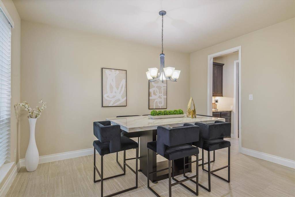 Bright dining room featuring large windows, stylish lighting, and beautiful tile floors for a refined look.