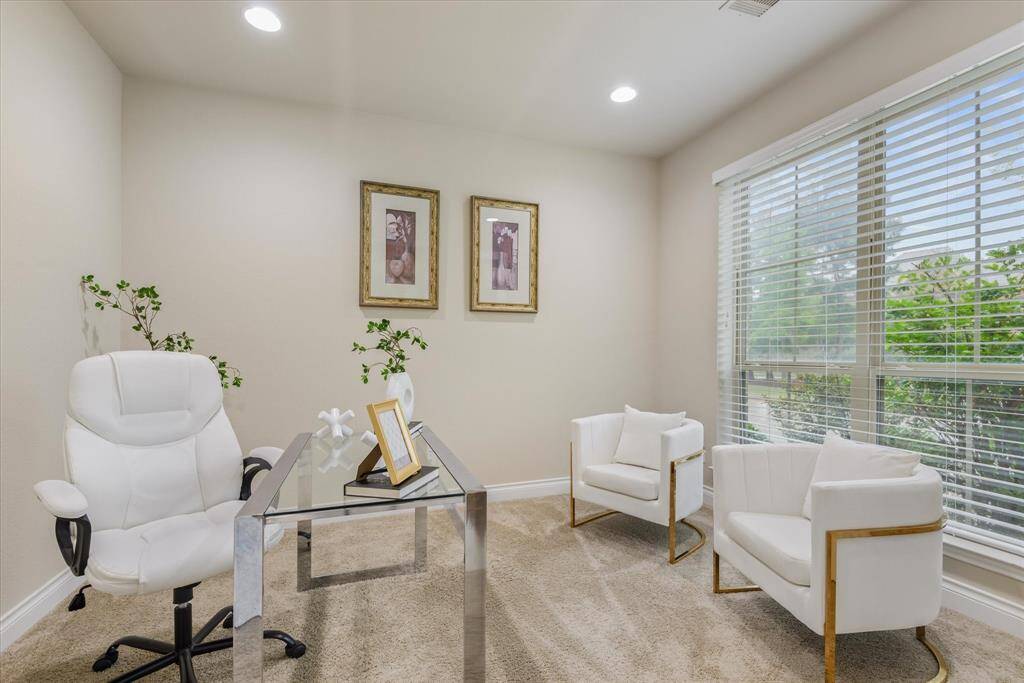 Quiet front office with plush carpet, large window for natural light, and ample space for work or study.
