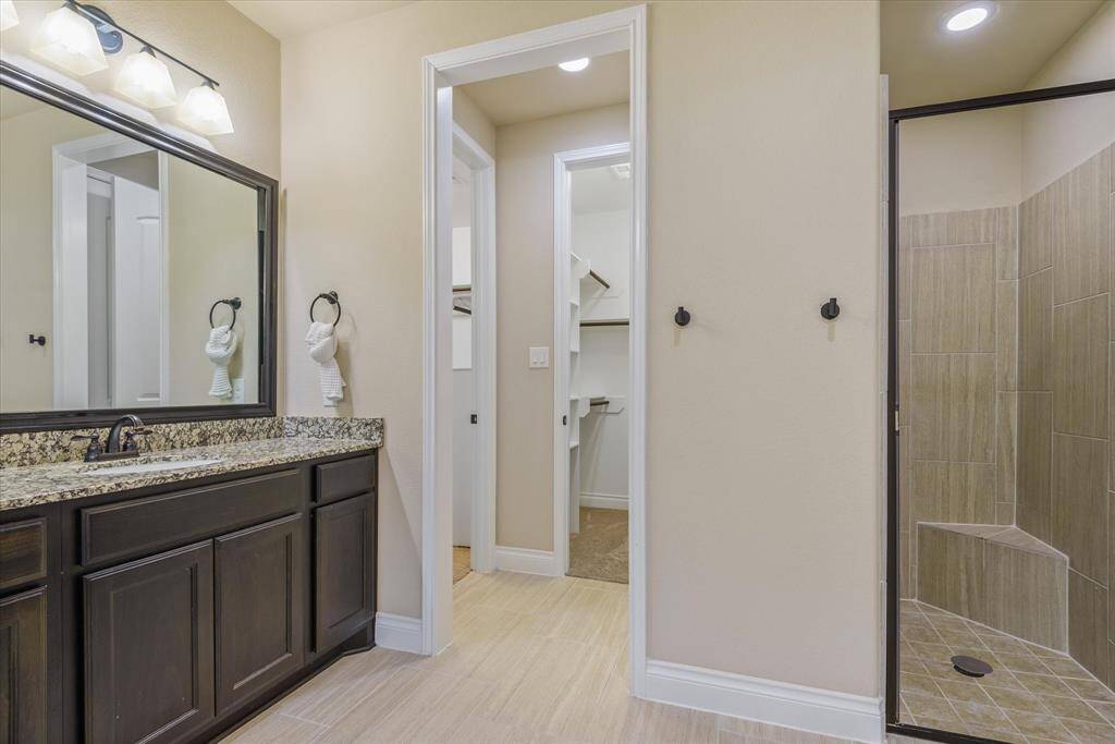 Master bathroom with a modern standup shower and a seamless flow leading into the spacious walk-in closet.