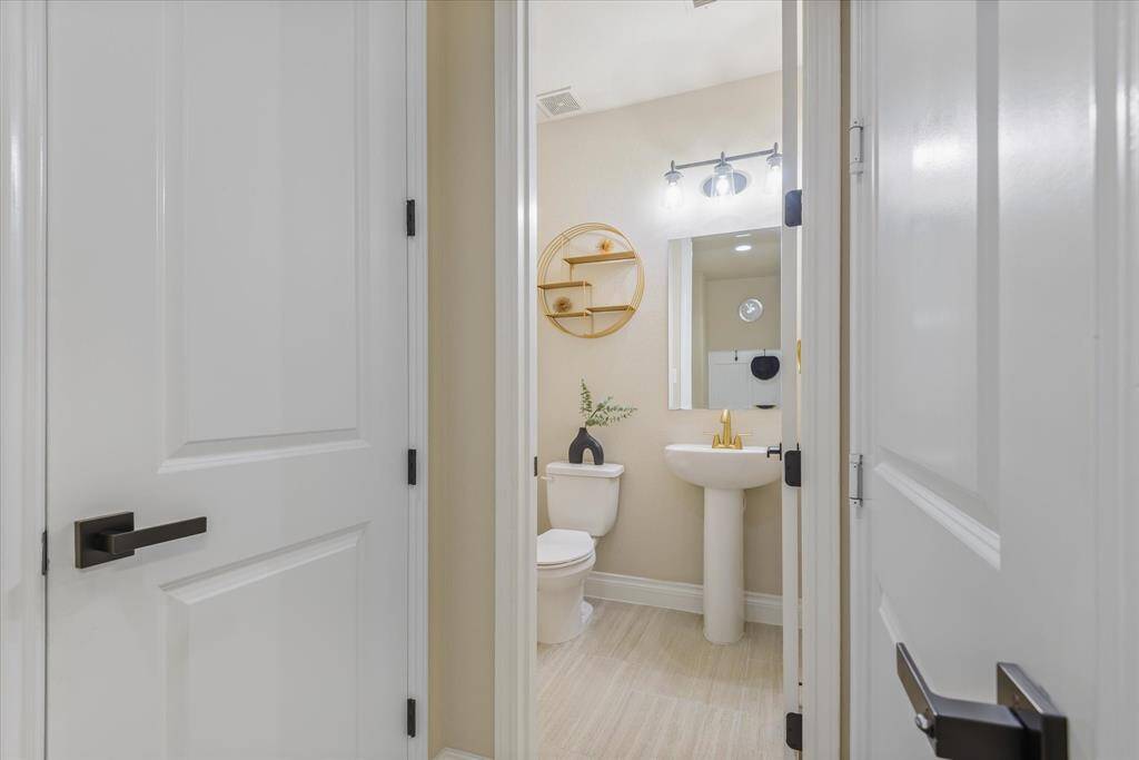Charming guest half bath with stylish fixtures, a sleek vanity, and modern finishes for a polished look.