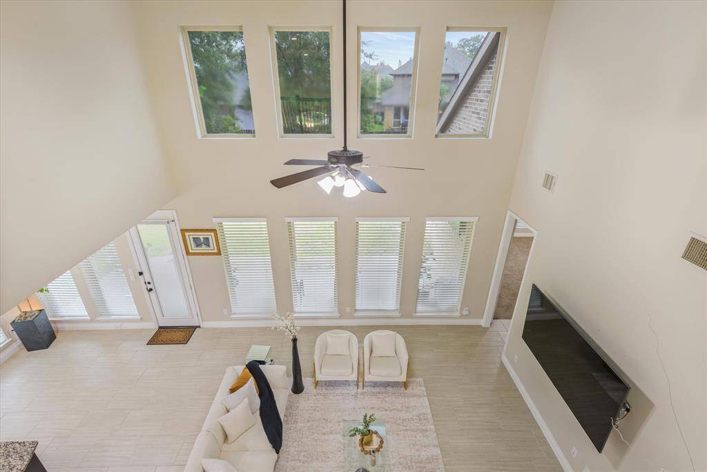 Open balcony view overlooking the bright living room below, showcasing spacious design and abundant natural light.