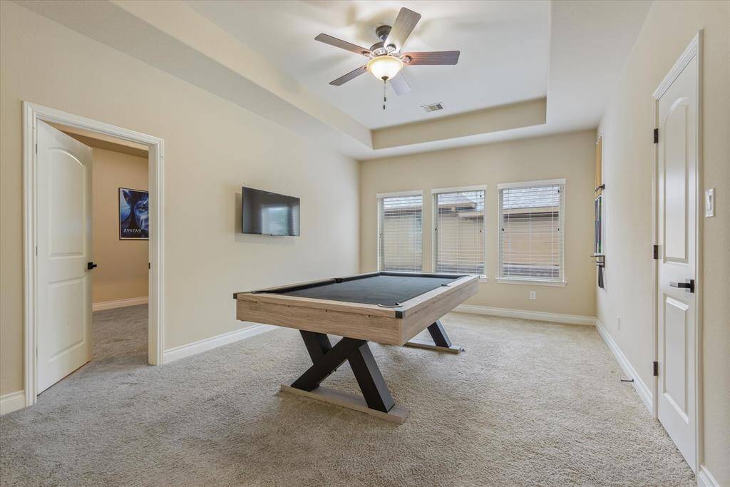 Game room filled with natural light and taller ceiling—currently with a pool table, which is not included with the home.
