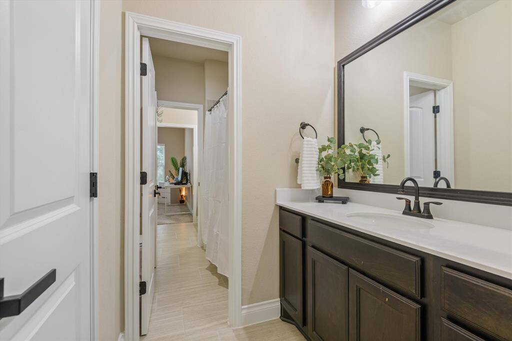 Shared Jack and Jill bathroom with dual sinks, modern fixtures, and a bright, functional layout between two bedrooms.