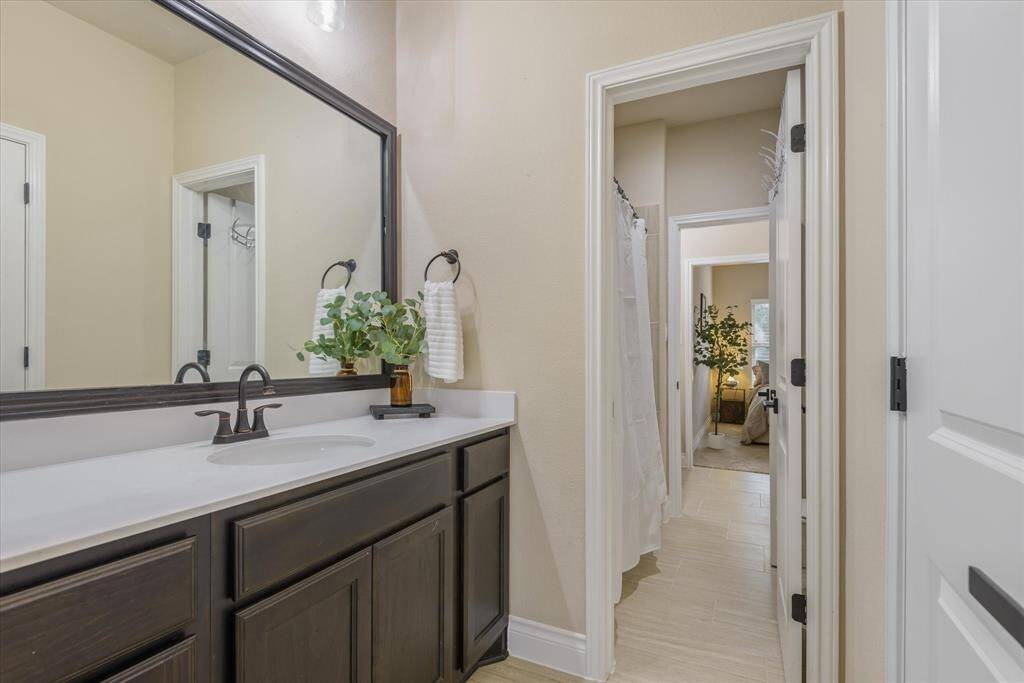 Jack and Jill bathroom viewed from a different angle, highlighting the dual sinks and spacious, well-lit design.