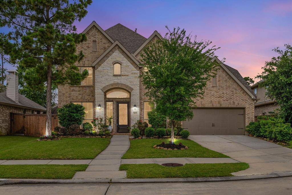 Twilight sets the scene as warm exterior lighting highlights the home’s charm and creates a welcoming evening glow.