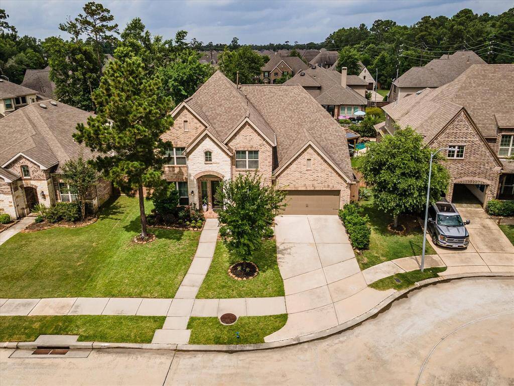 Aerial drone view showcasing the home’s impressive curb appeal, surrounding landscaping, and neighborhood setting.