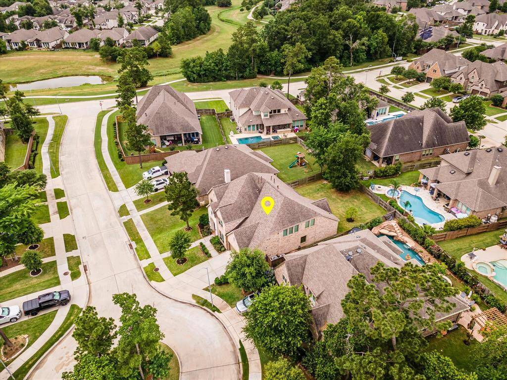 Drone shot from a different angle, highlighting the neighborhood layout and the home’s position along the quiet street.
