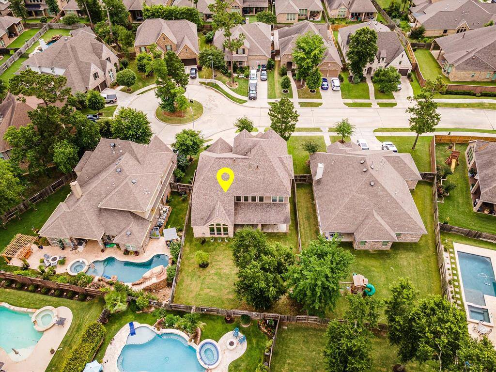 Drone photo from a third angle, showcasing the neighborhood layout and clear views of the homes along the street.
