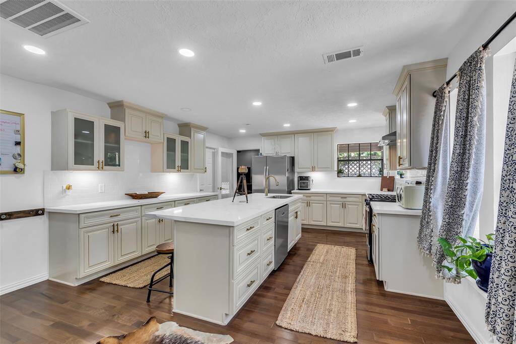 Angle showcasing the abundant counter space, glass-front cabinetry, and designer finishes. Perfect for culinary creations or hosting.