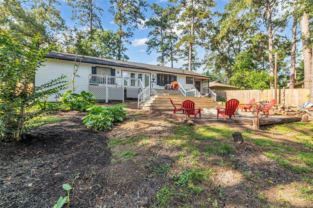 Another angle of the private backyard showcasing tiered landscaping, lush greenery, and the charming fire pit area – ideal for enjoying nature or hosting gatherings.
