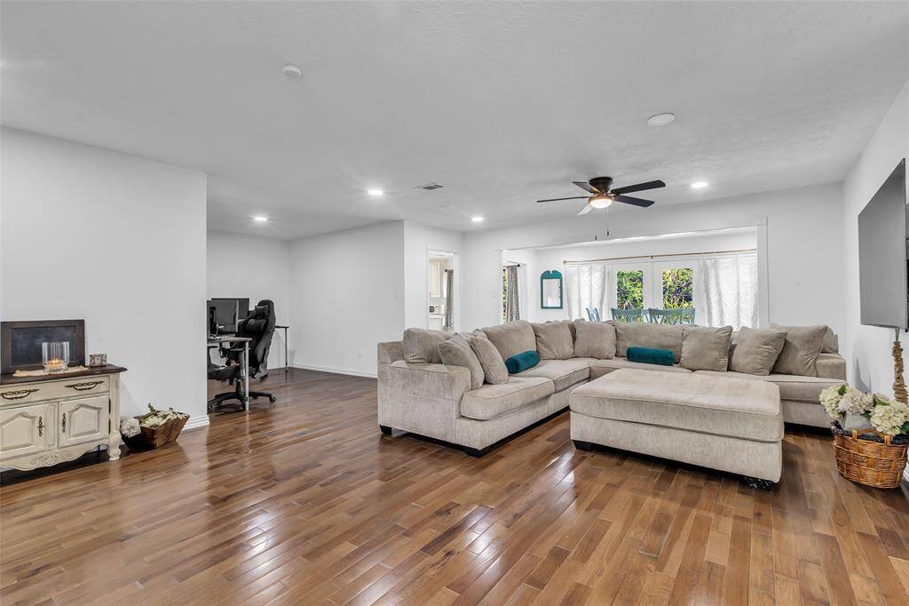 Expansive living area with hardwood floors, recessed lighting, and large sectional space. Flows seamlessly into dining and kitchen areas—ideal for entertaining.