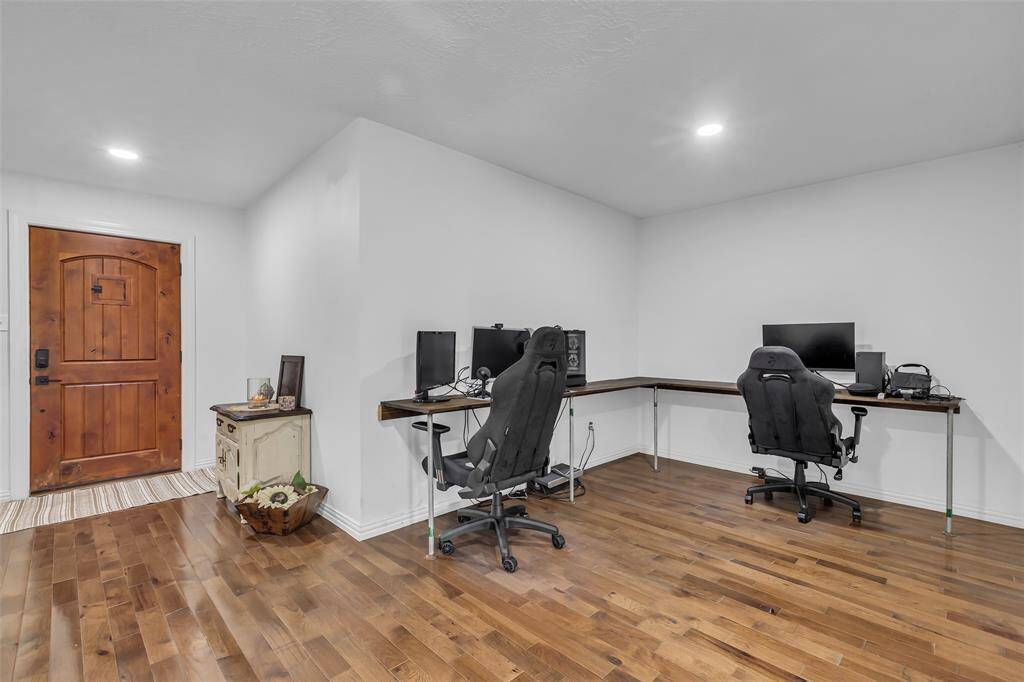 Dedicated home office setup with dual workstation capacity and hardwood floors—just off the rustic wood front door entry. Flexible use for work-from-home or study.