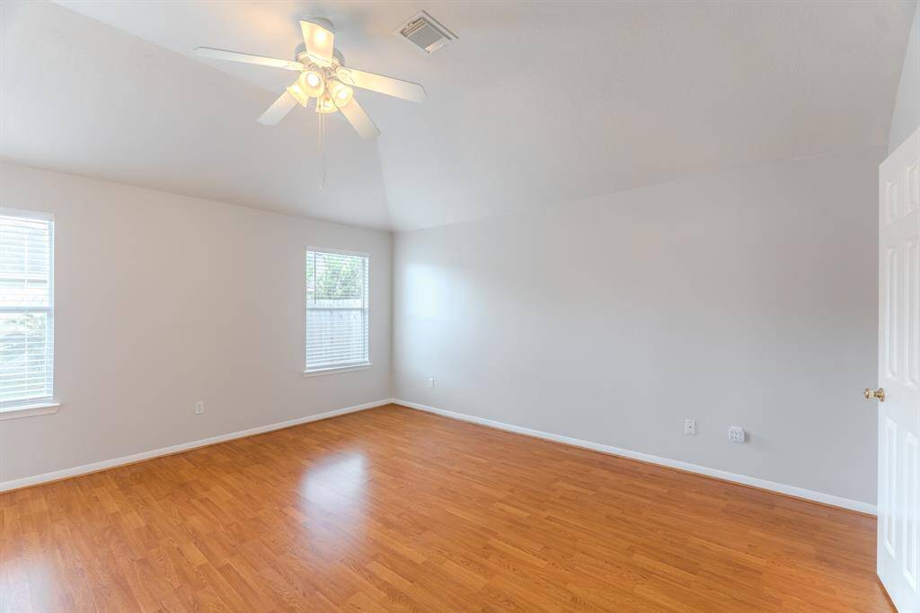 The primary bedroom offers high ceilings, abundant natural light, and direct access to the en-suite bathroom and walk-in closet