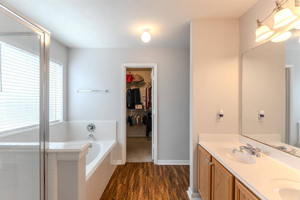 The primary bathroom features dual sinks, a soaking tub, and a separate shower, all seamlessly connected to the walk-in closet for added convenience