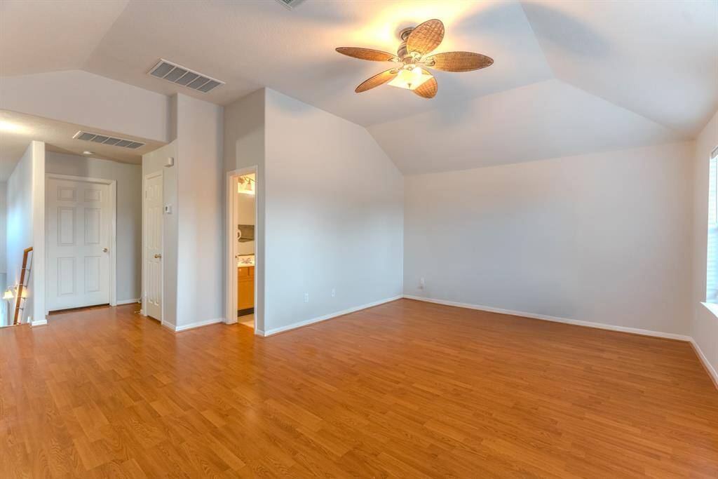 The spacious game room, with high ceilings and plenty of natural light, offers convenient access to a bathroom — perfect for guests, game nights, or even a home gym.