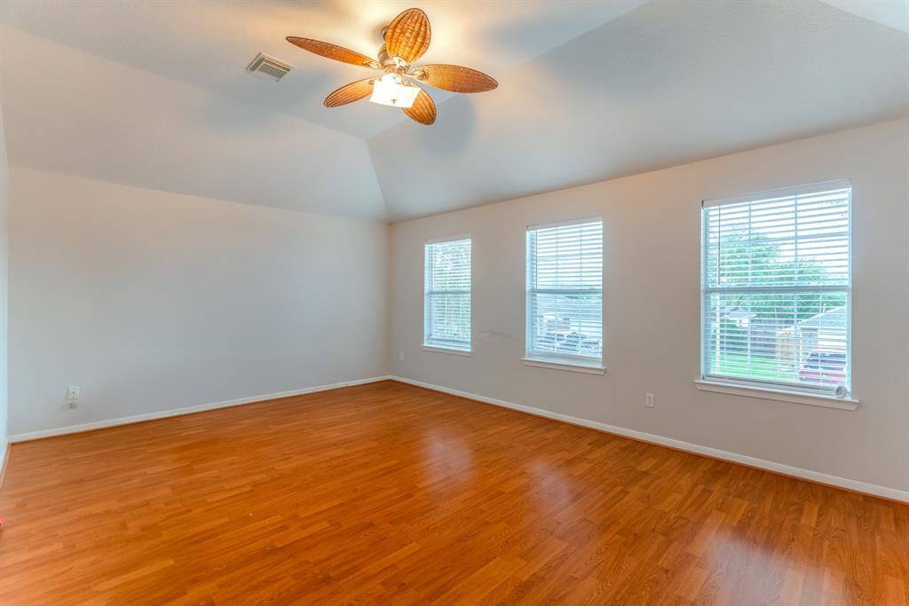 The spacious game room, with high ceilings and plenty of natural light, offers convenient access to a bathroom — perfect for guests, game nights, or even a home gym.