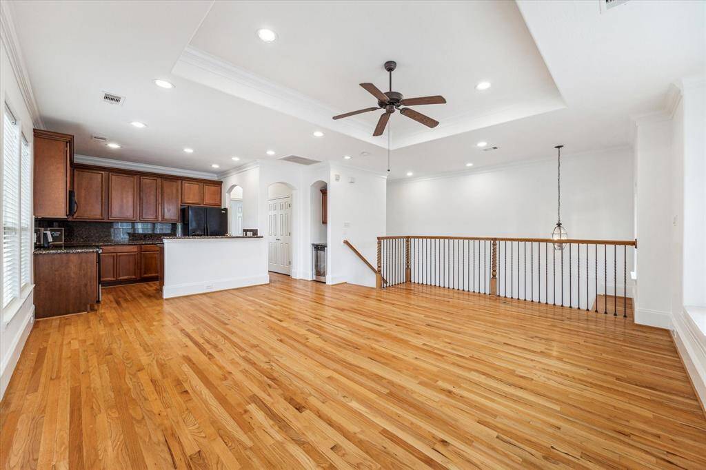 Spacious living room with recessed lighting, crown molding and wood plank flooring.