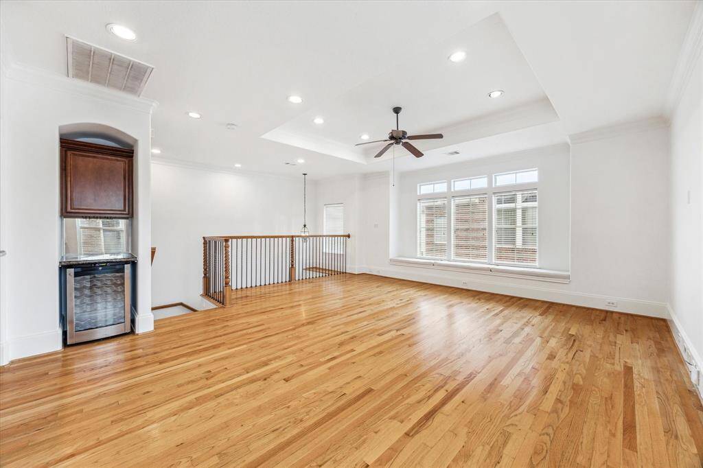 Another view of the spacious living area bathed in natural light. Wood flooring throughout this living area.