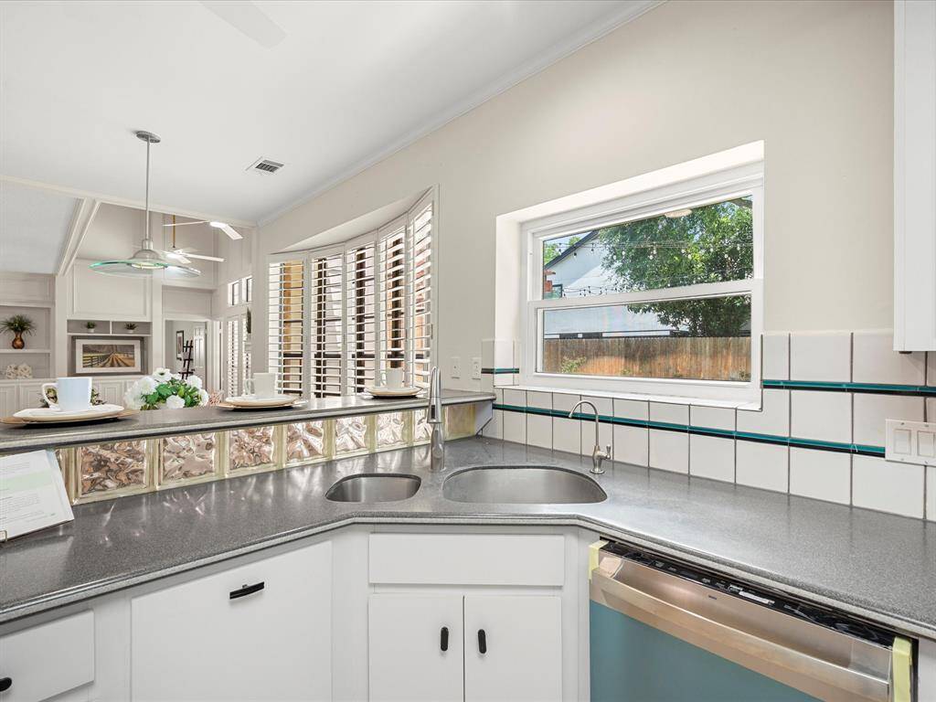 Wash up with a view—window above the sink offers a serene look at the pool