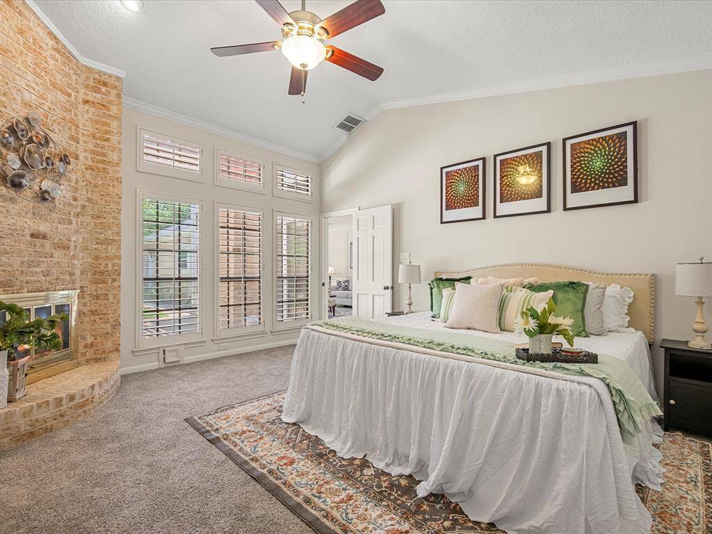 Spacious primary retreat featuring a unique tiled ceiling, cozy fireplace, and plenty of windows that offer serene views of the sparkling pool—creating a peaceful and luxurious atmosphere.
