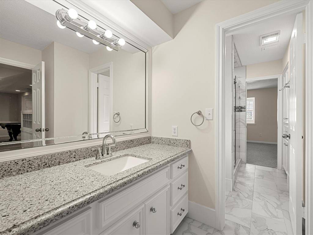 Spacious fourth bedroom with a walk-in closet and a private vanity that connects to a shared full bath—offering both comfort and convenience.