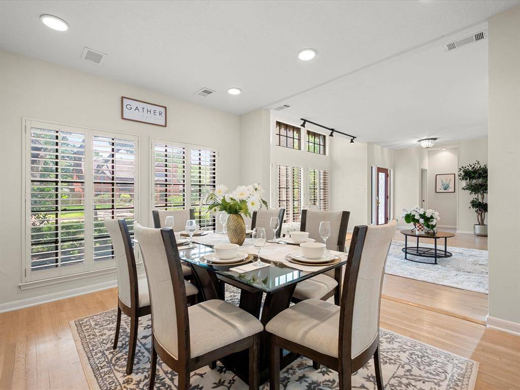Bright and airy formal dining room featuring tall ceilings and multiple windows
