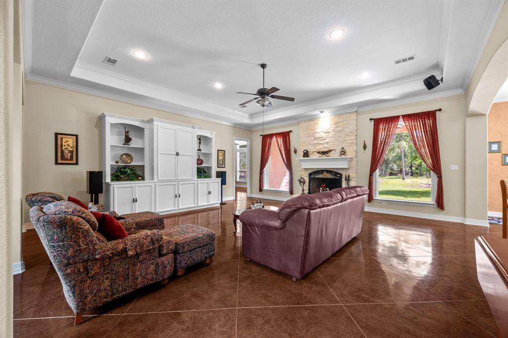 Soaring tray ceiling, recessed lighting and full-height stone fireplace anchor this open gathering space—ideal for both quiet evenings and entertaining.