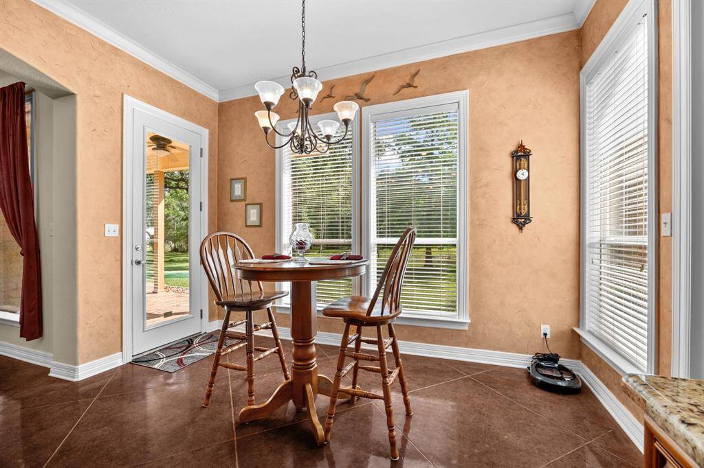 Warm textured walls, a decorative chandelier and windows create an intimate spot for morning coffee, with direct access to the covered patio and backyard.