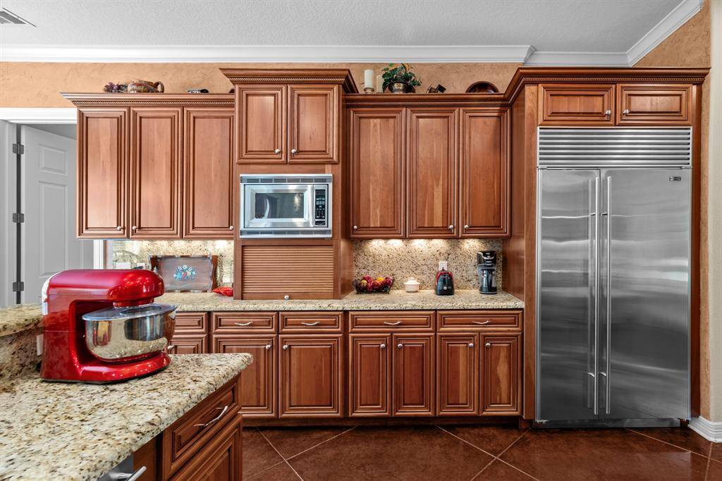 Concealed bread box/appliance garage, built-in microwave, and expansive granite counter combine style and function in one streamlined wall.