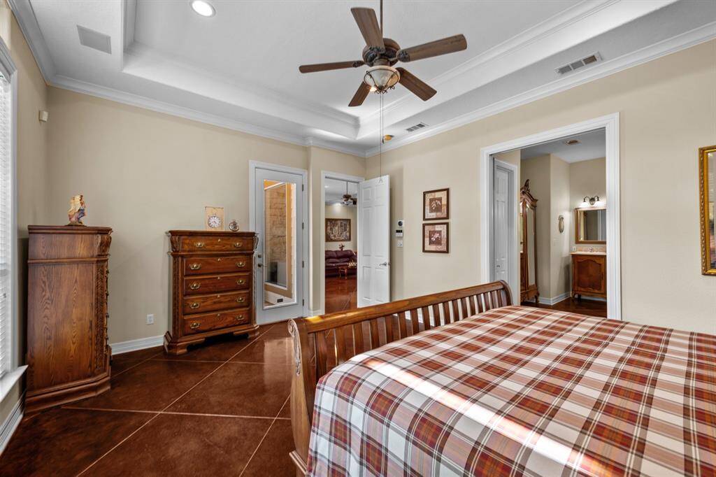 View toward the private patio door and dual bath entrances, showcasing easy access to outdoor relaxation and the spa-style primary bath beyond.