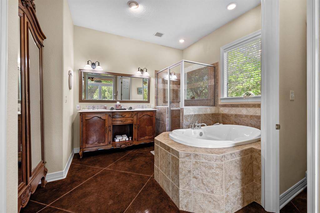 Antique-style double vanity with stone-topped cabinets, twin sinks, and oversized mirror—perfect for morning routines and shared use.