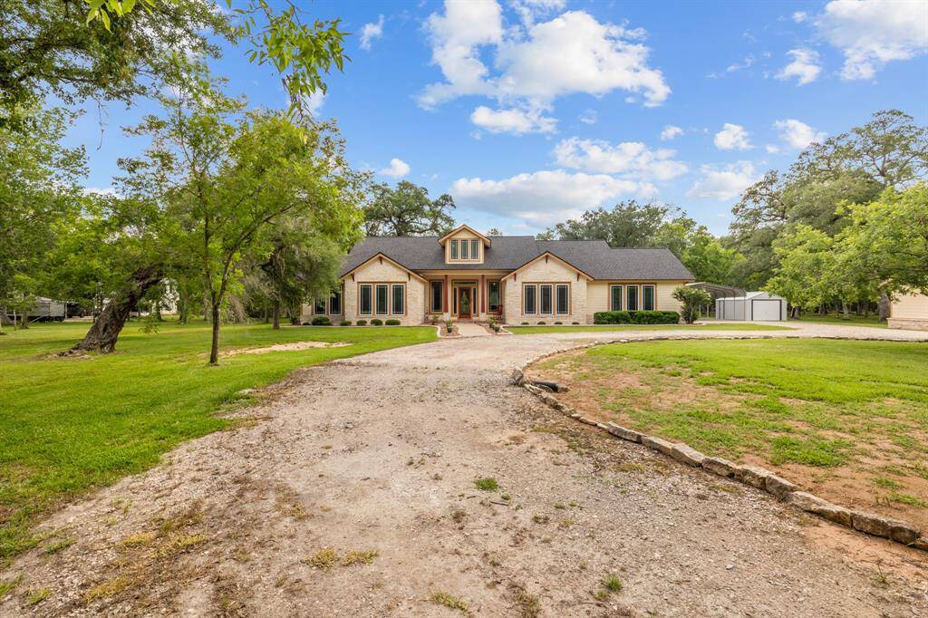 Wide-angle view illustrates the home’s generous footprint and adjacent carport/storage shed, perfect for RVs, boats or workshop space.