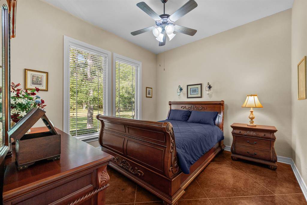The 3rd bedroom with a ceiling fan and large windows looking onto the views of the outdoors.