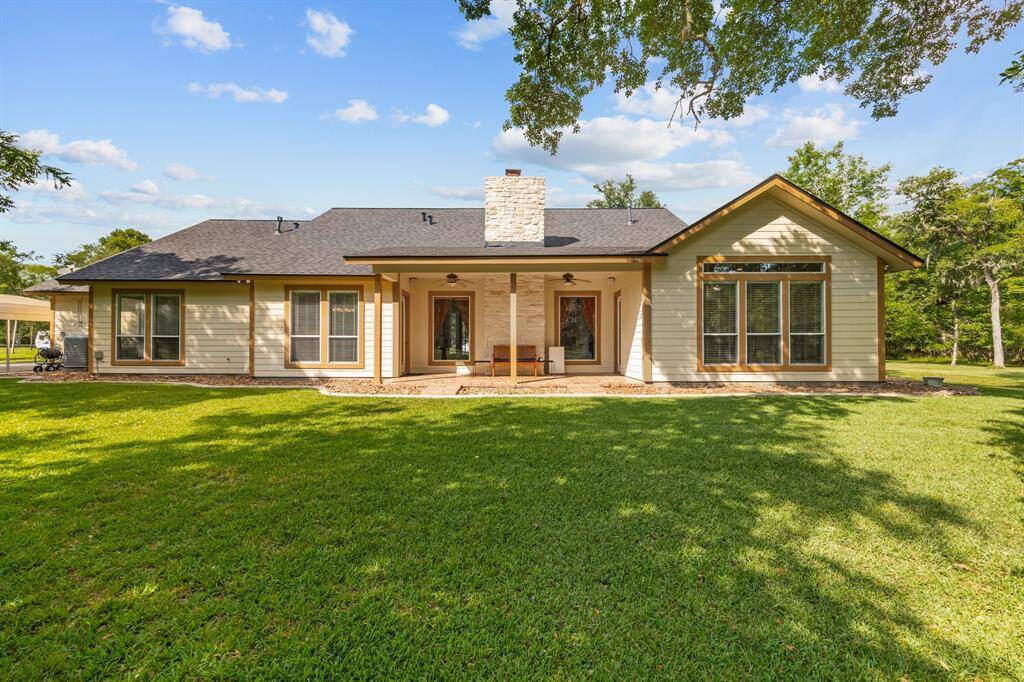 Inviting covered patio, with ceiling fans overhead and a paved terrace perfect for year-round outdoor enjoyment.