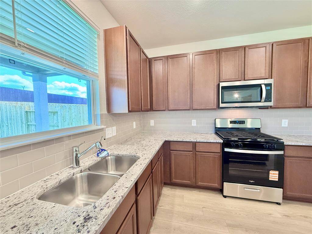 A window by the kitchen sink lets in plenty of natural light, brightening up the space