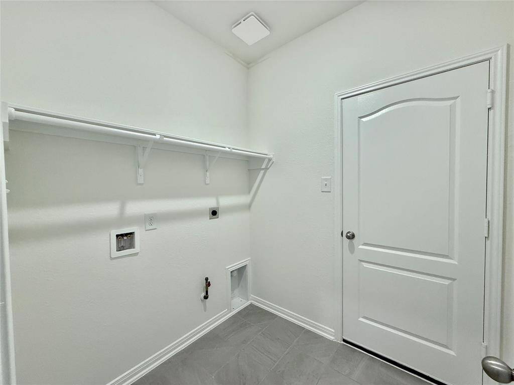 Utility room offers electric and gas dryer connections, plus easy access to the garage with the tankless on-demand water heater.