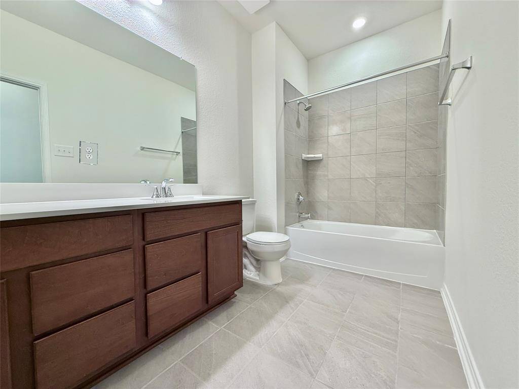 Huge secondary bathroom with ample cabinet space, a vanity area, and a soaking tub