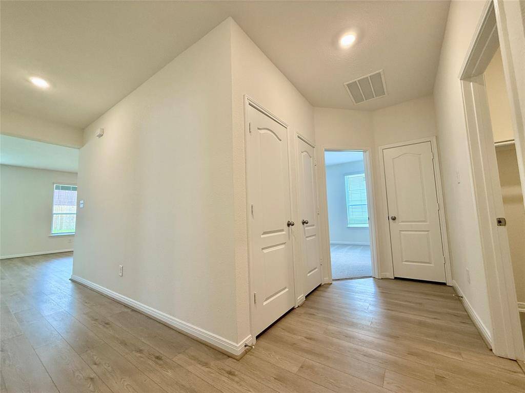 To the right of the foyer, you’ll find the utility room, spacious primary bedroom, and generous closets for plenty of storage.