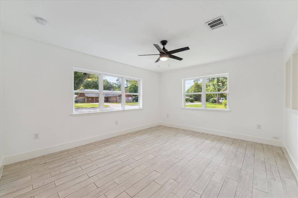 Family room located just inside the home with views of front yard.  Two walls of windows allow the natural light to flow in.