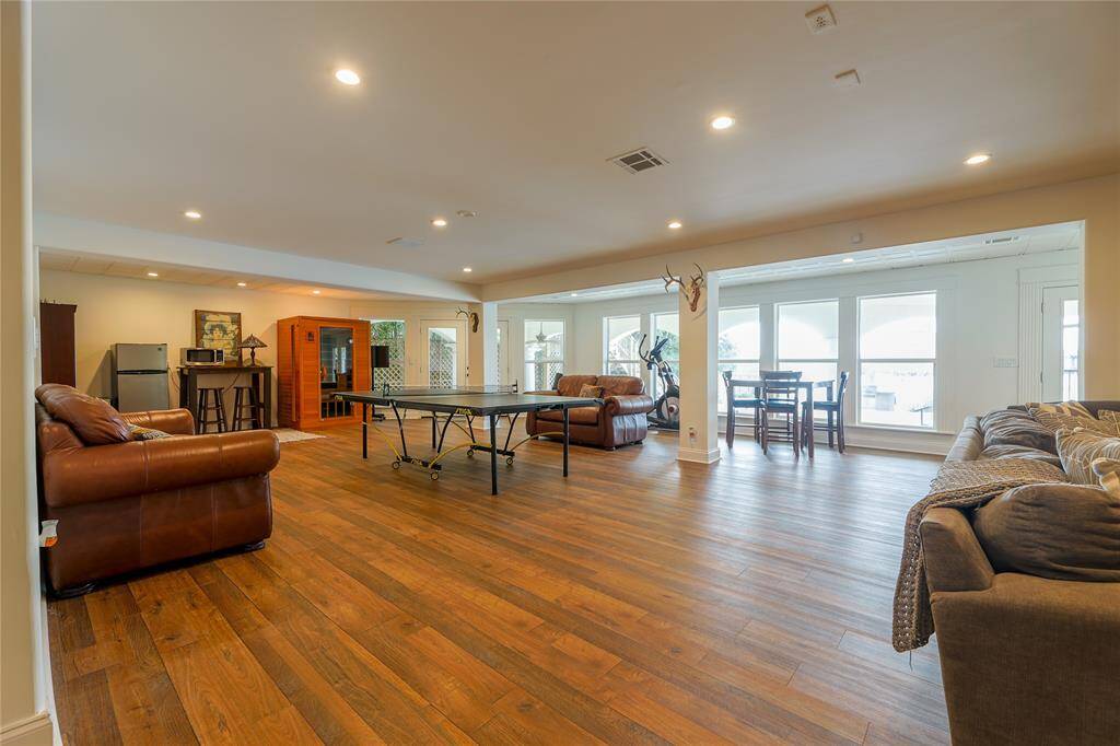 Spacious recreation room with wood flooring, featuring ample space, perfect for relaxation and entertainment!