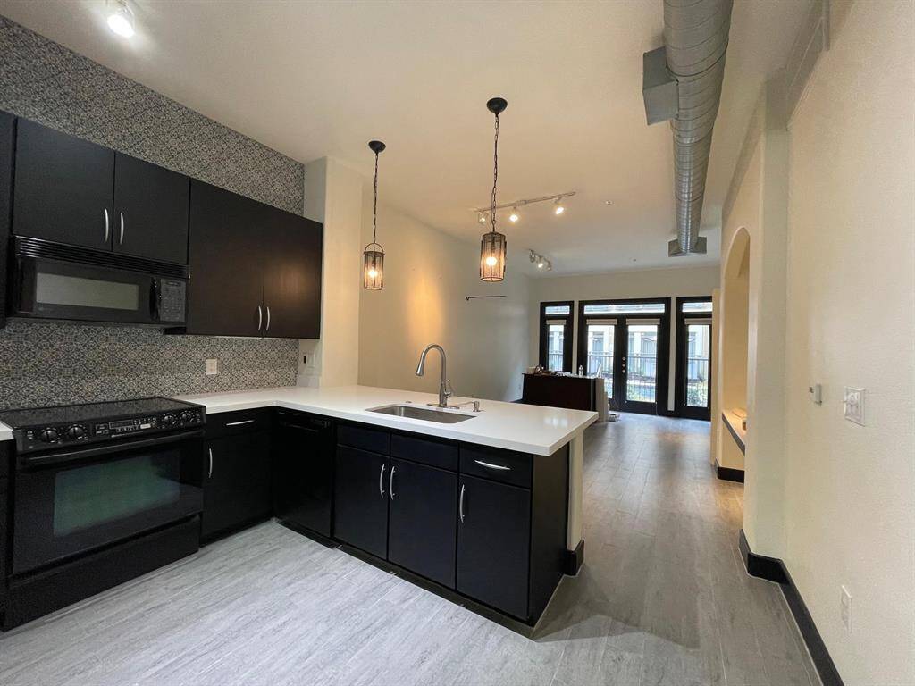 The kitchen features an open-concept layout that flows seamlessly into the living room, complete with durable, low-maintenance quartz countertops. Enjoy your morning coffee while taking in views of the pool and open courtyard.