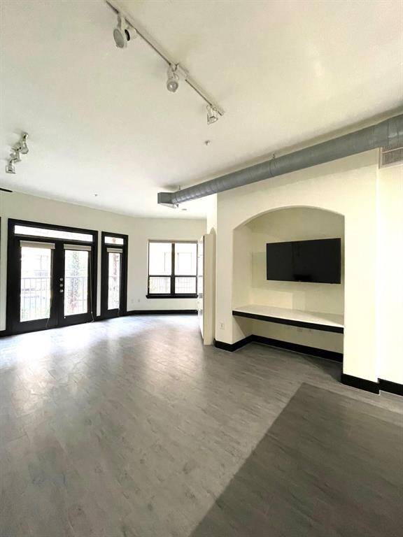 spacious living, full of natural light, providing a nook for desk/office/ TV.
