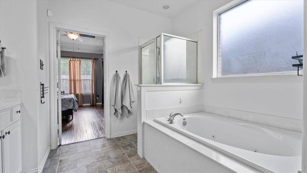 The primary bath includes a separate soaking tub and walk-in shower for added comfort