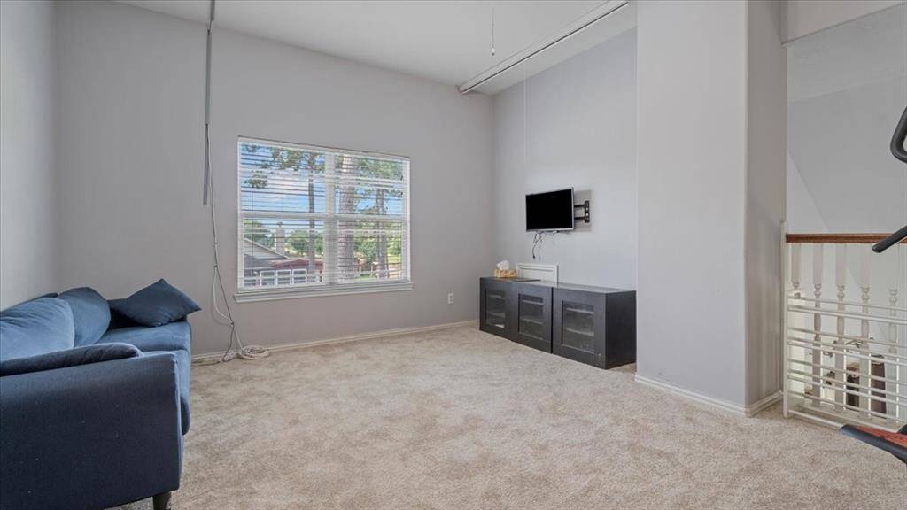 Upstairs game room features a projector screen, creating the perfect spot for family movie nights or game-day viewing.